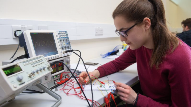 Student operates equipment at a desk