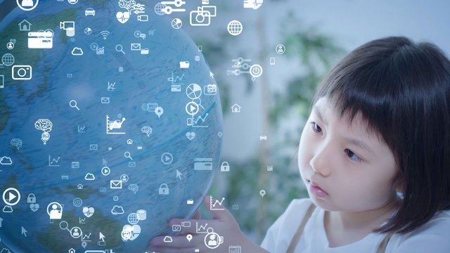 Child looking at global with lots of symbols floating around