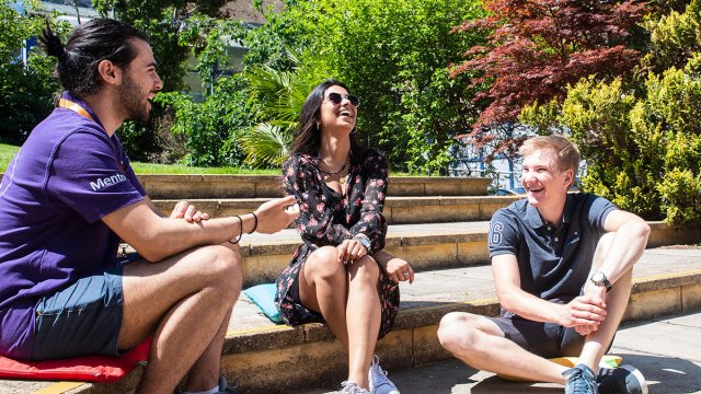 Student sat on steps laughing together