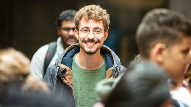 Student stands in a busy campus 