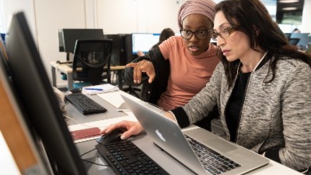 Students study together around a computer 