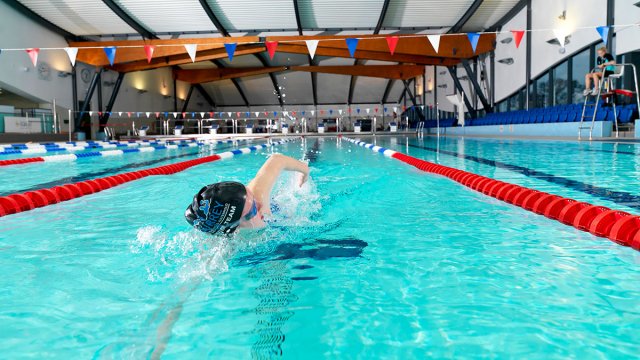 Swimmer doing front crawl in the Olympic-sized pool at Surrey Sports Park