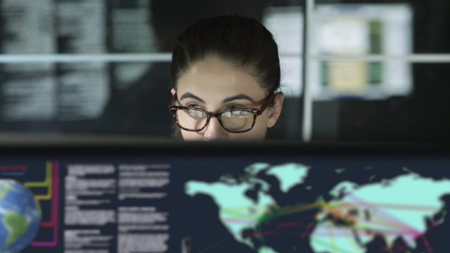 Woman looking at a computer screen with map of the world