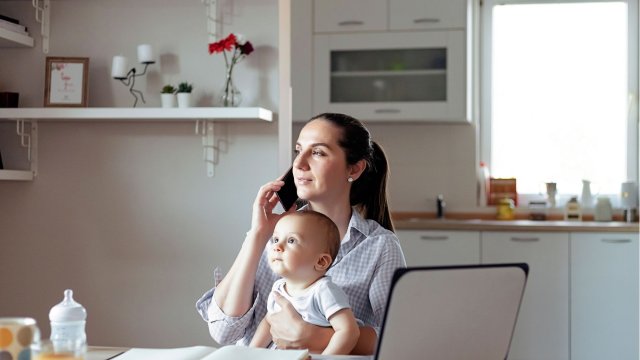 Mother working whilst holding baby