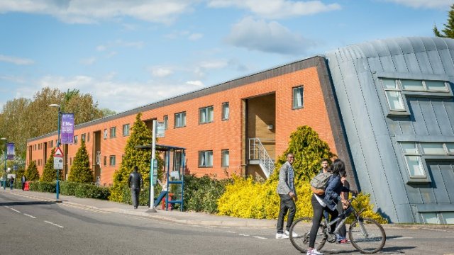 Students walking and cycling outside university accommodation