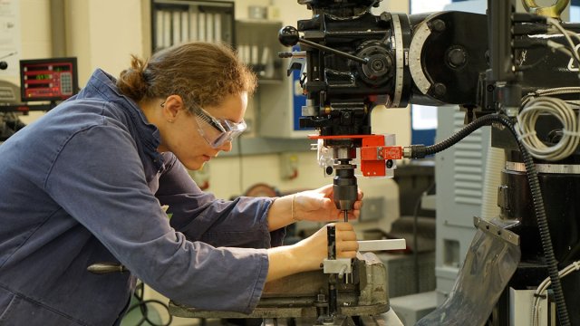 Student using mechanical engineering equipment