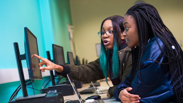 Two female computer science students discuss their work