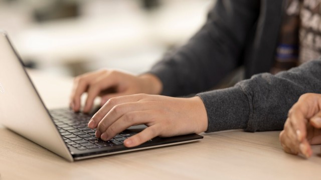 Student typing on laptop