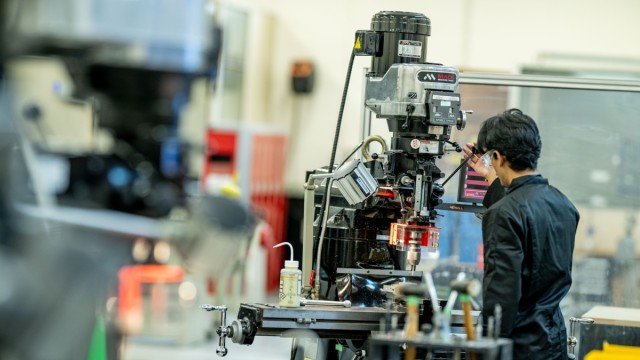 A student operating a machine in the University's mechanical engineering lab