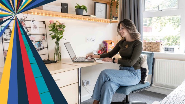 Female student using laptop at desk in student accommodation