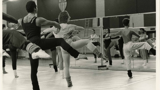 Group of dancers practicing in studio, in black and white.