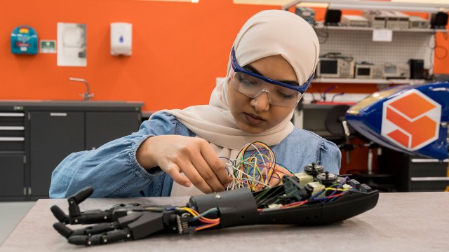 Biomedical engineering student fixing robotic arm