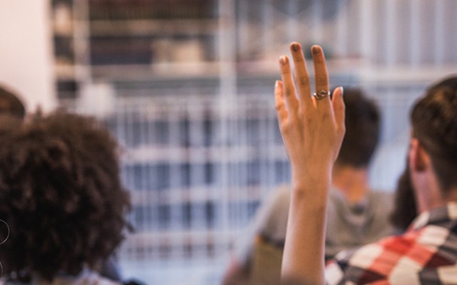 a women raising her hand at a seminar