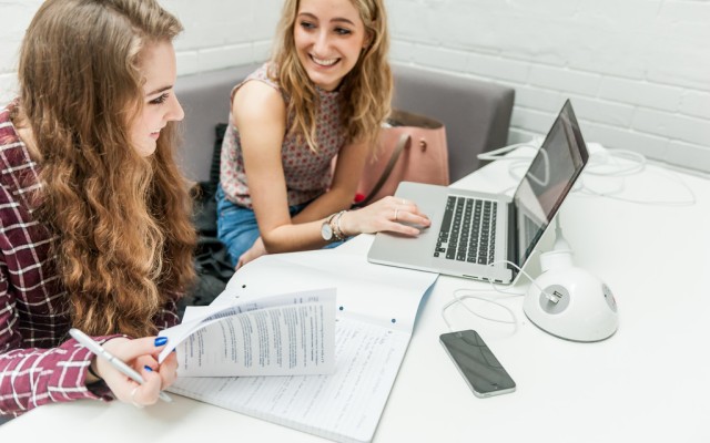 Students studying with a laptop and a notepad