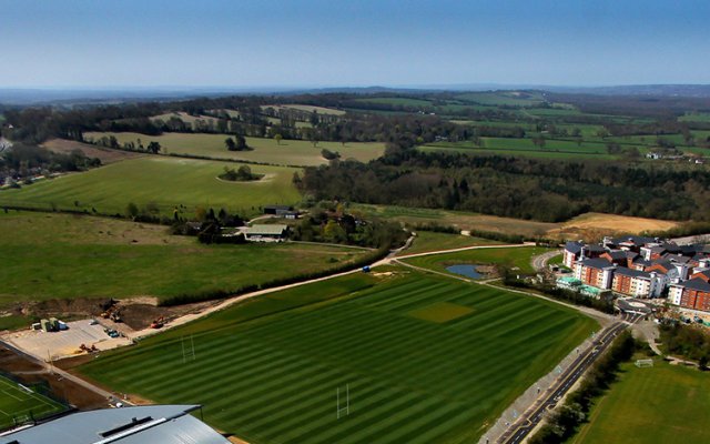 Ariel shot of Surrey Sports Park, showing blue sky and green grass