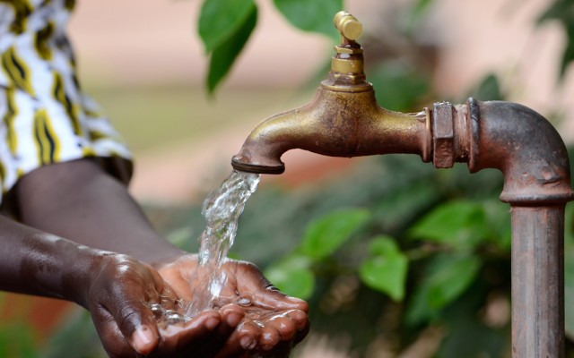 Hand cupping water coming out of a tap.