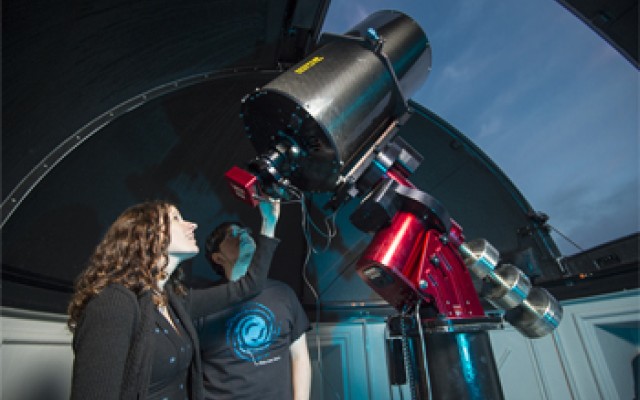 Woman using a large telescope