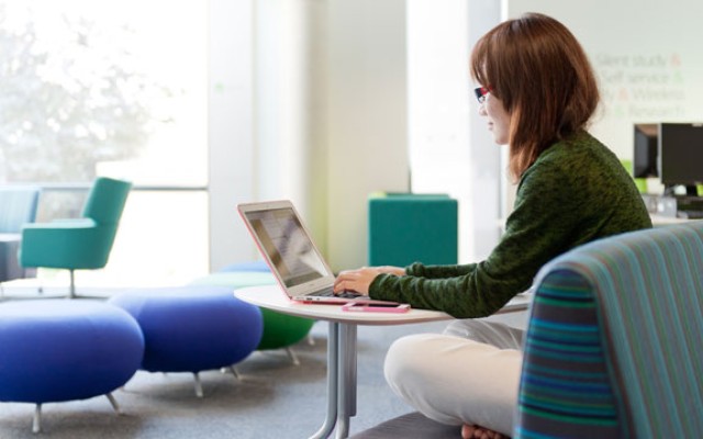 Female student studying in the Library on her laptop