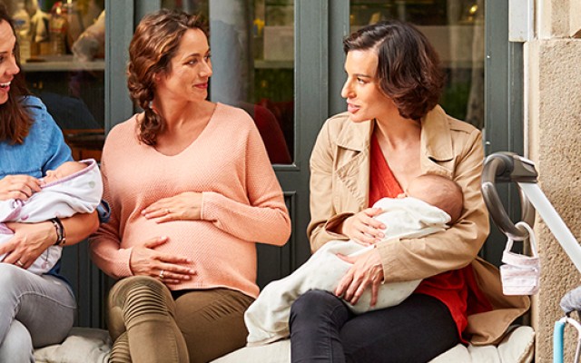 Expectant and friends with babies sitting on bench