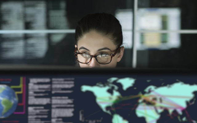 Woman looking at a computer screen with map of the world