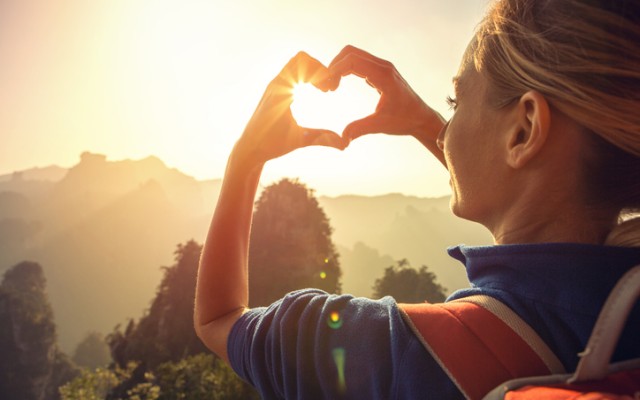 Sustainable tourism image with woman making heart-shape with hands