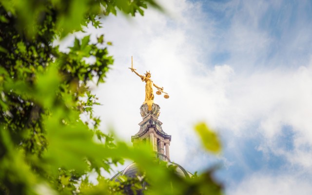 The gold coloured statue of Lady Justice, holding a sword and scales, on top of the dome of the Old Bailey, England's criminal court in the City of London