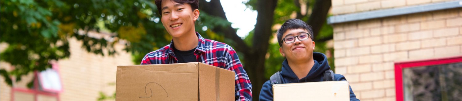 Two students carrying boxes