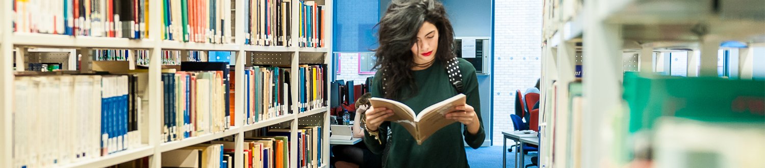 Female student reading book in library