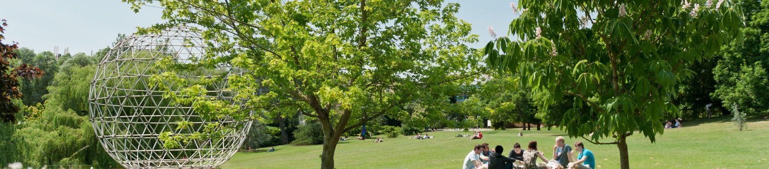 Globe sculmpure and students sat on grass