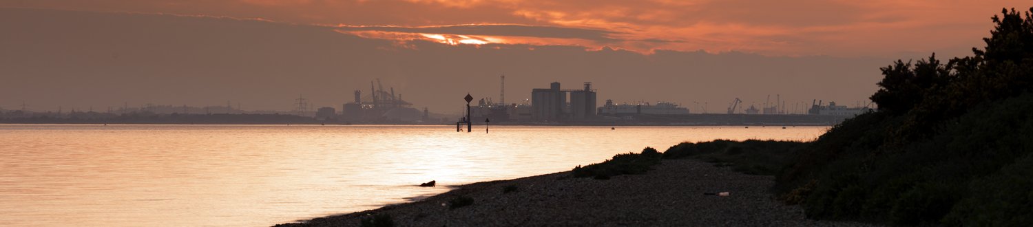Chemical factory across the water at sunset