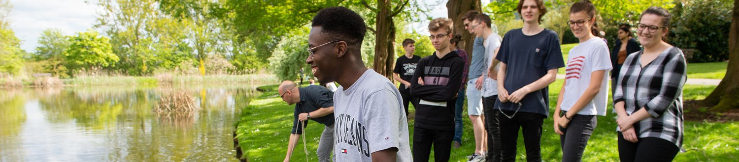 students conducting an experiment by the lake on campus