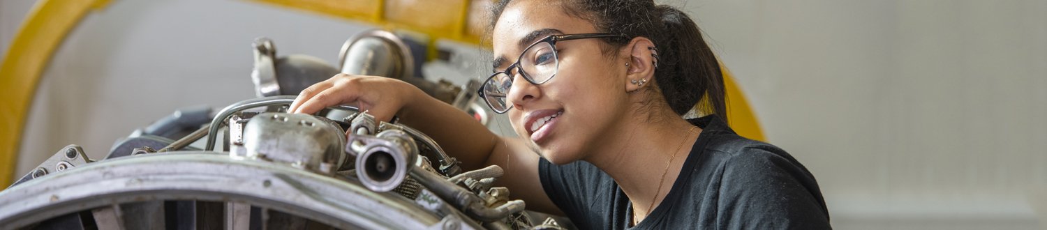 Woman working on mechanical engineering equipment