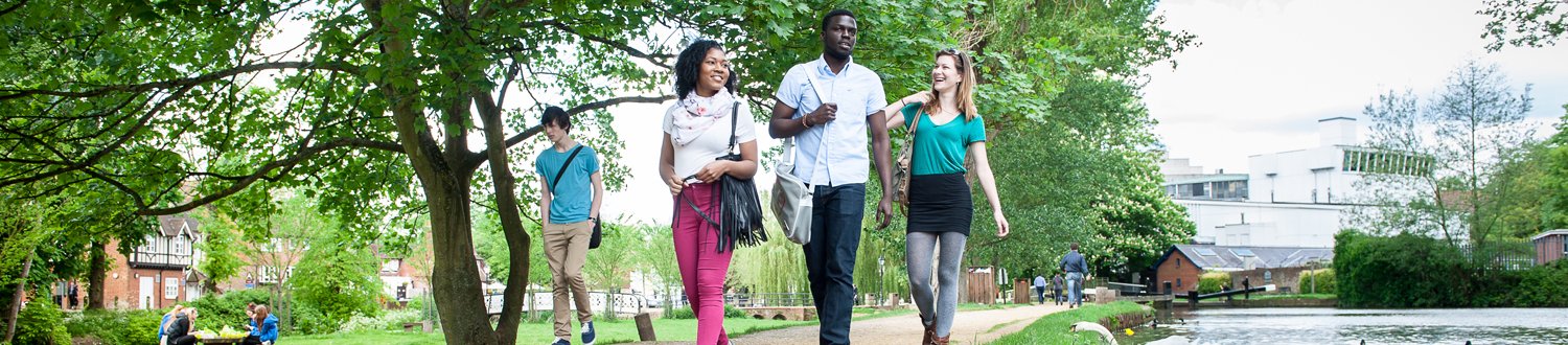 Students walking along river Wey