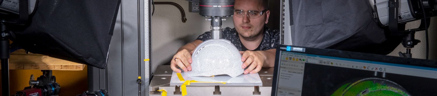 Male student using mechanical engineering equipment