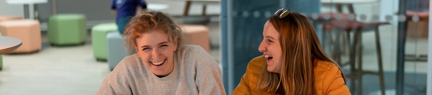Two female students laughing.
