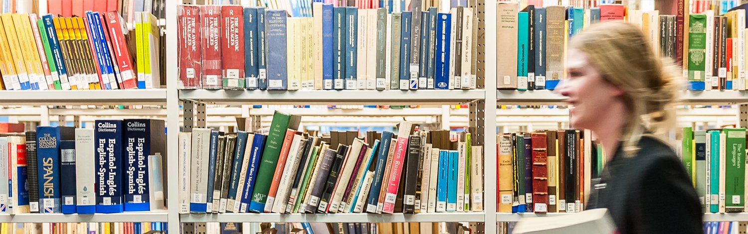 Female student walking past bookcases