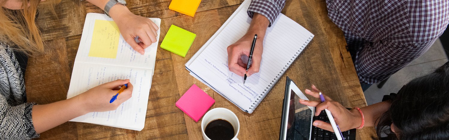 Notepads and post-it notes on table from above.