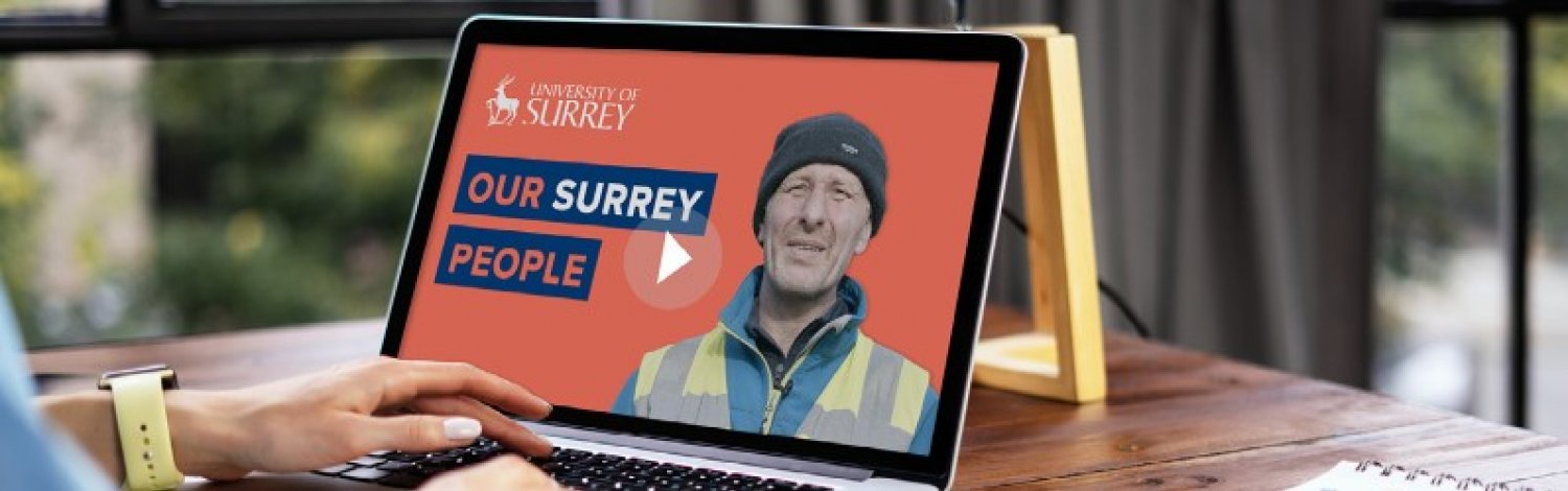 A person is looking at a laptop with an Our Surrey People video on the screen.