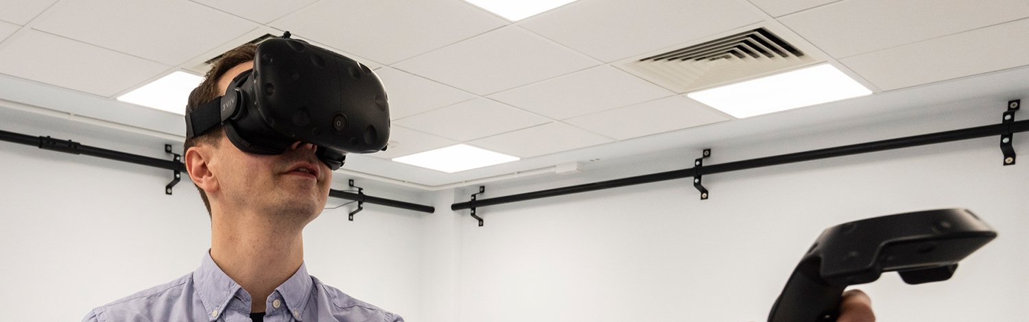 A man using a virtual reality headset in the Psychology extended reality suite.