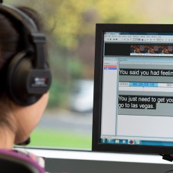 Student using translation software on computer screen whilst wearing headphones