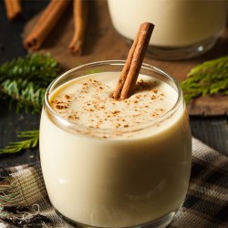 Glass of eggnog with a cinnamon stick in