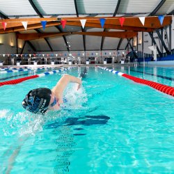 Swimmer doing front crawl in the Olympic-sized pool at Surrey Sports Park