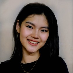 a woman with medium-length black hair, smiling warmly at the camera. 