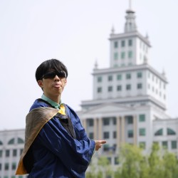 Zheyu points at a building.