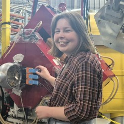 Claire standing by an experimental setup at TRIUMF.