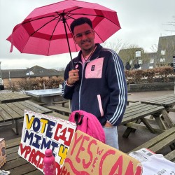 University of Surrey Public Affairs MSc student, Matt, underneath an umbrella