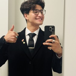 Student taking a selfie against white backdrop 