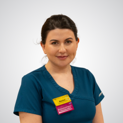 Rachel wears nursing scrubs and smiles at the camera.