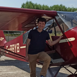 Profile picture showing me in front of a red Piper Cub.