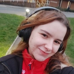 Julia wears headphones and smiles in a selfie.